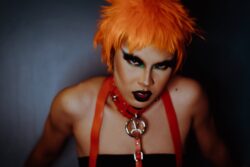 eccentric woman with dark makeup and dyed orange hair